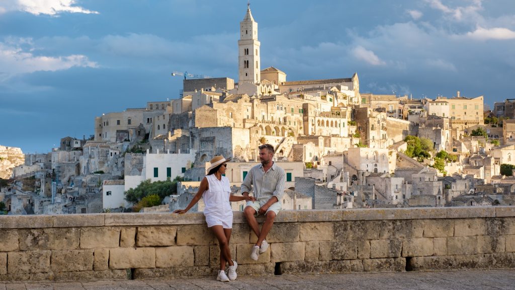 Un couple aime la superbe vue du coucher du soleil sur l'architecture de matera ancienne en pierre dans les Pouilles, en Italie